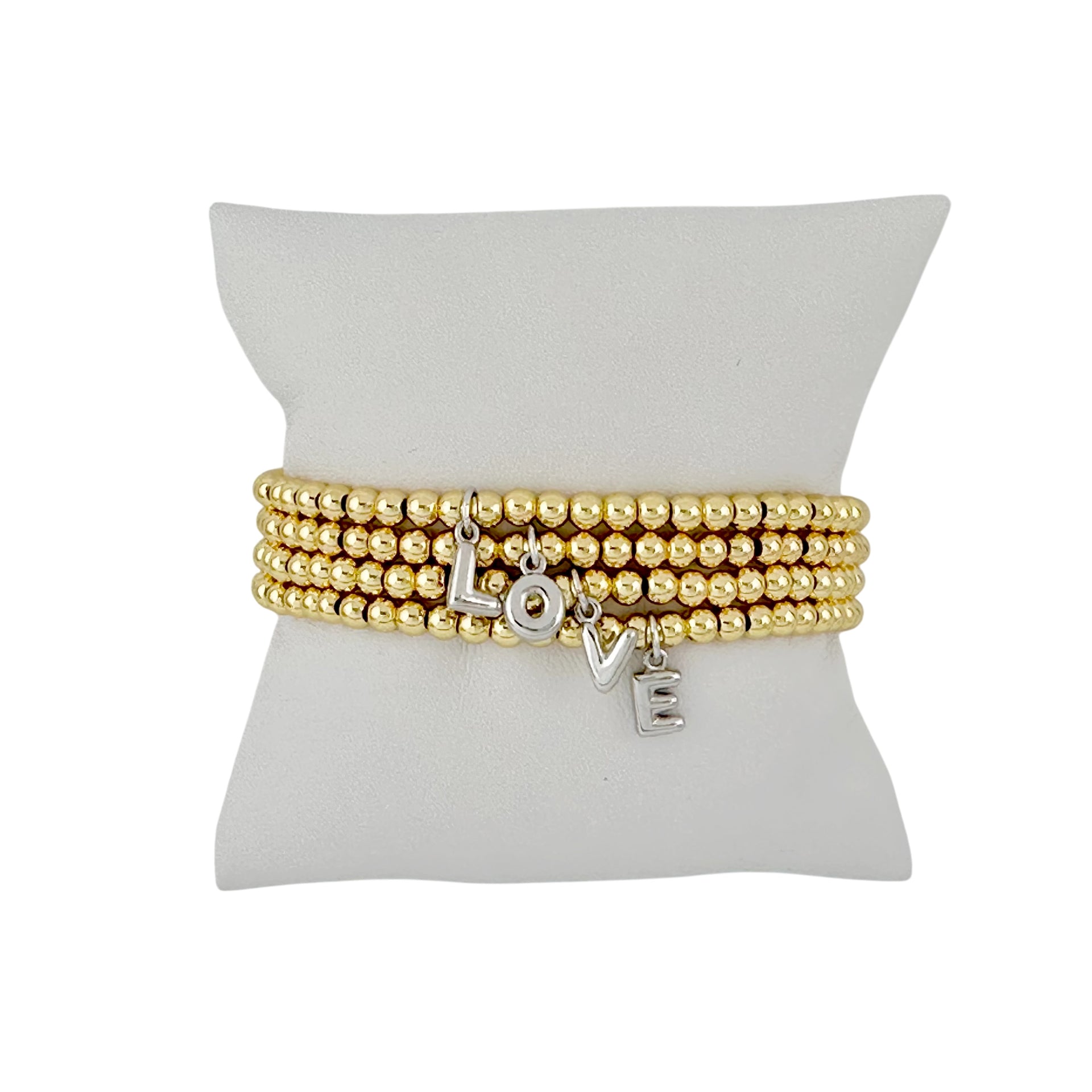 gold lila bubble letter initial bracelet displayed on jewelry pillow showing polished beaded design