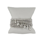 silver lila bubble letter initial bracelet displayed on jewelry pillow showing polished beaded design
