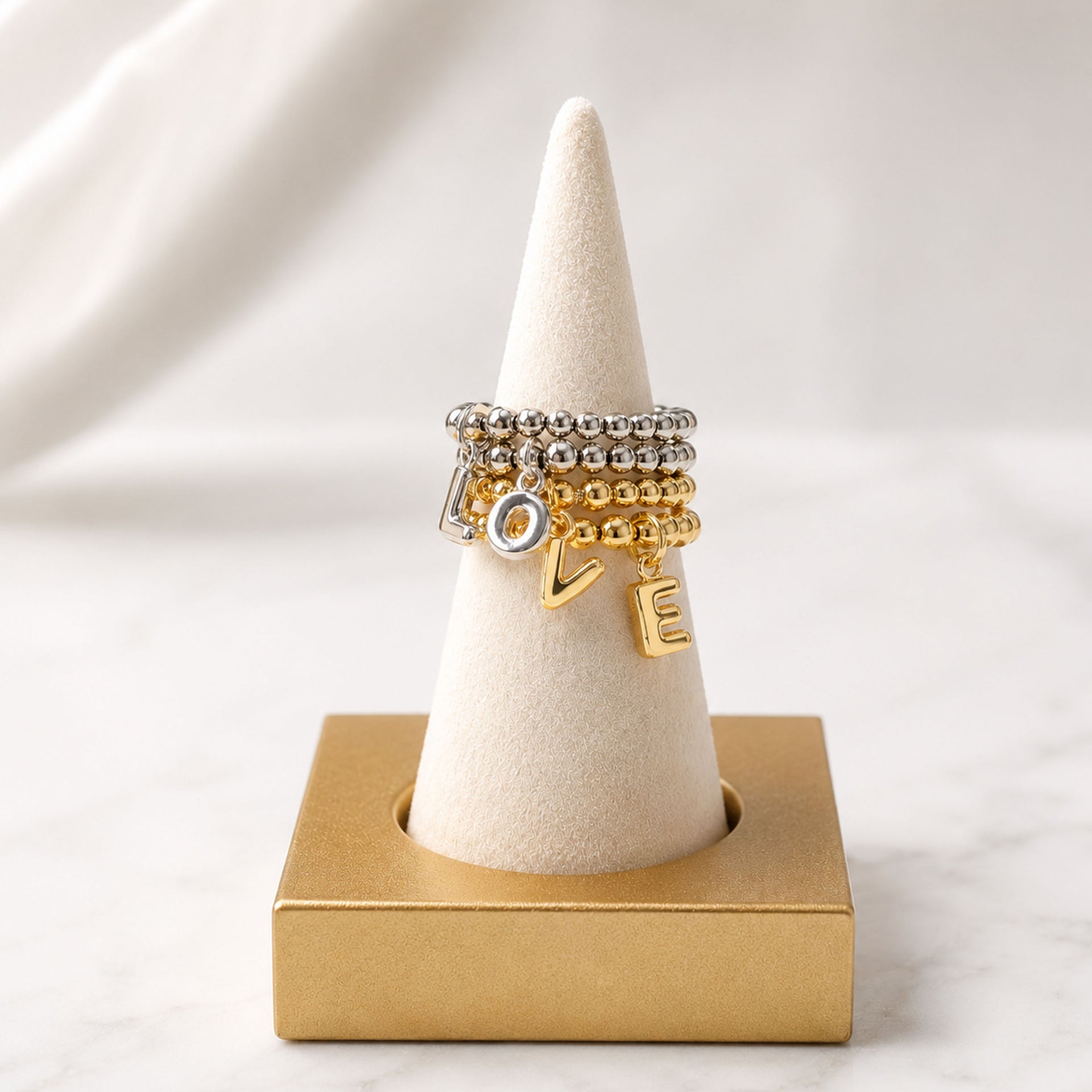 Love Lisa Lila Bubble Letter Initial Stretch Rings displayed on ring cone in gold and silver letter charm styles