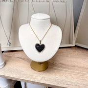 lila diamond heart necklace in black displayed on jewelry bust with gold chain and black cz heart pendant