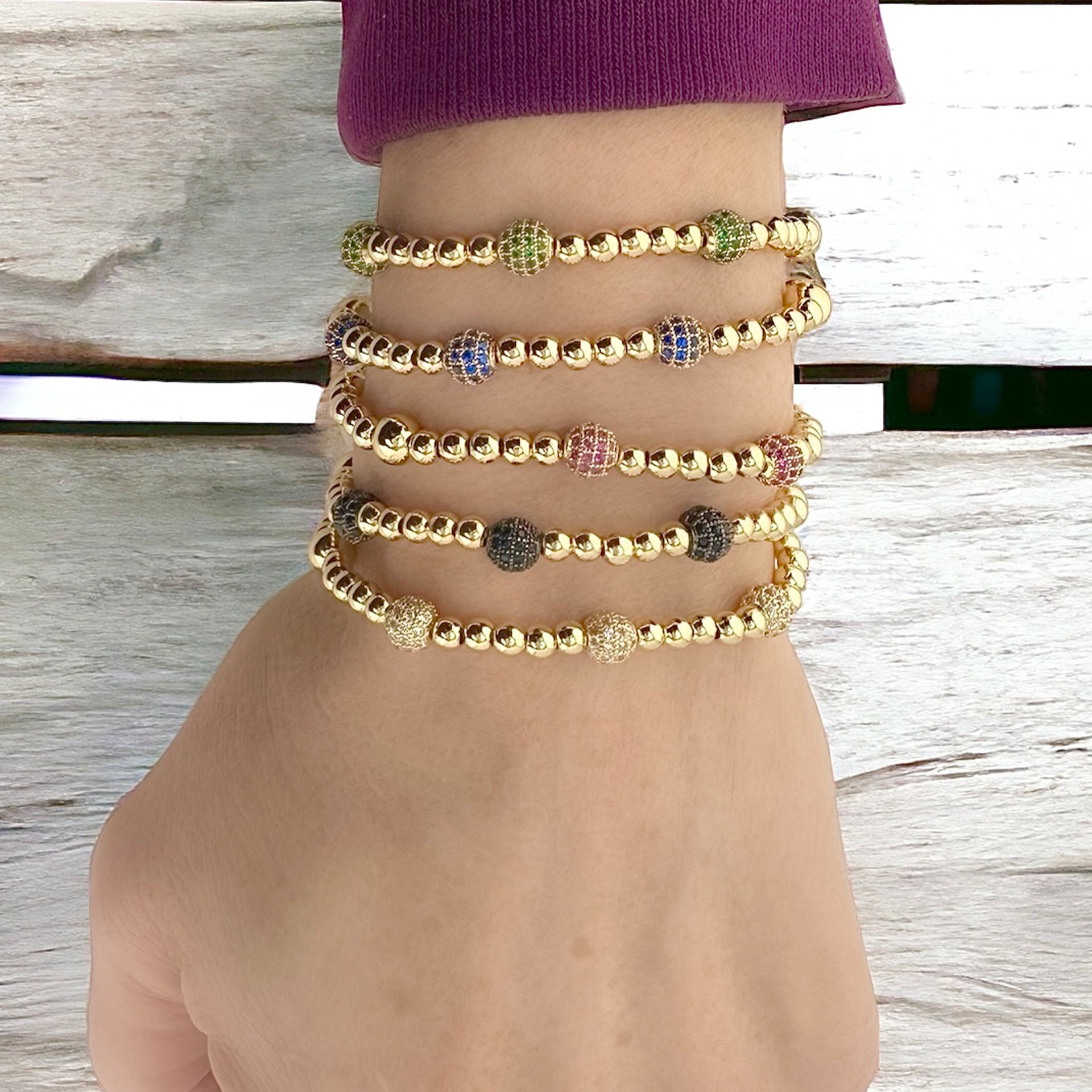 stack of gold lilly pave bracelets worn on wrist showing layered beaded and pave bead details