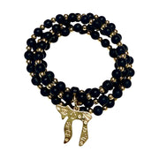 Liora Gemstone Beaded Chai Necklace with matte black onyx beads, gold-tone accent beads, and a gold Chai to Life pendant shown coiled 