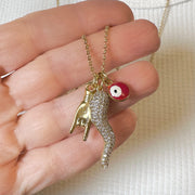 hand holding gold Italian horn necklace showing detailed CZ horn charm evil eye charm and hand charm
