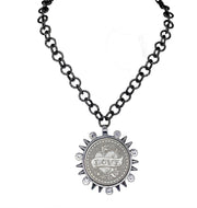 black chain necklace with large silver LOVE coin pendant surrounded by spike and crystal accents on white background