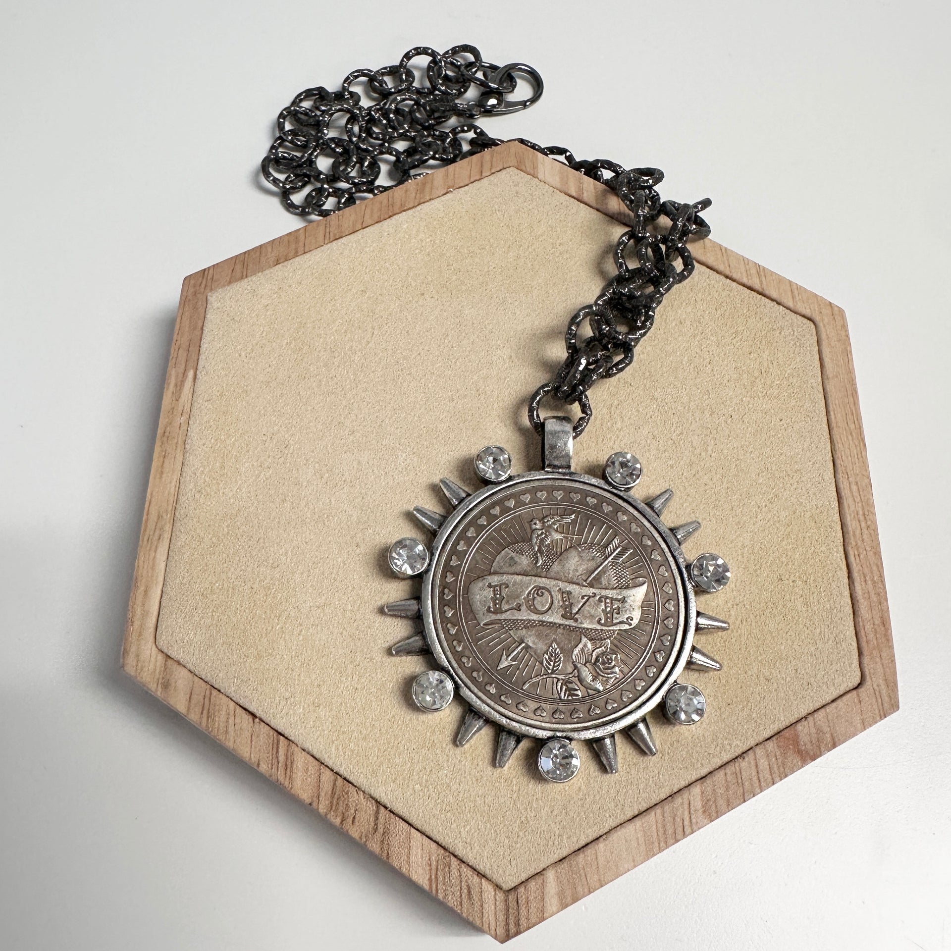 LOVE coin necklace displayed in gift box showing silver pendant with spikes and crystals
