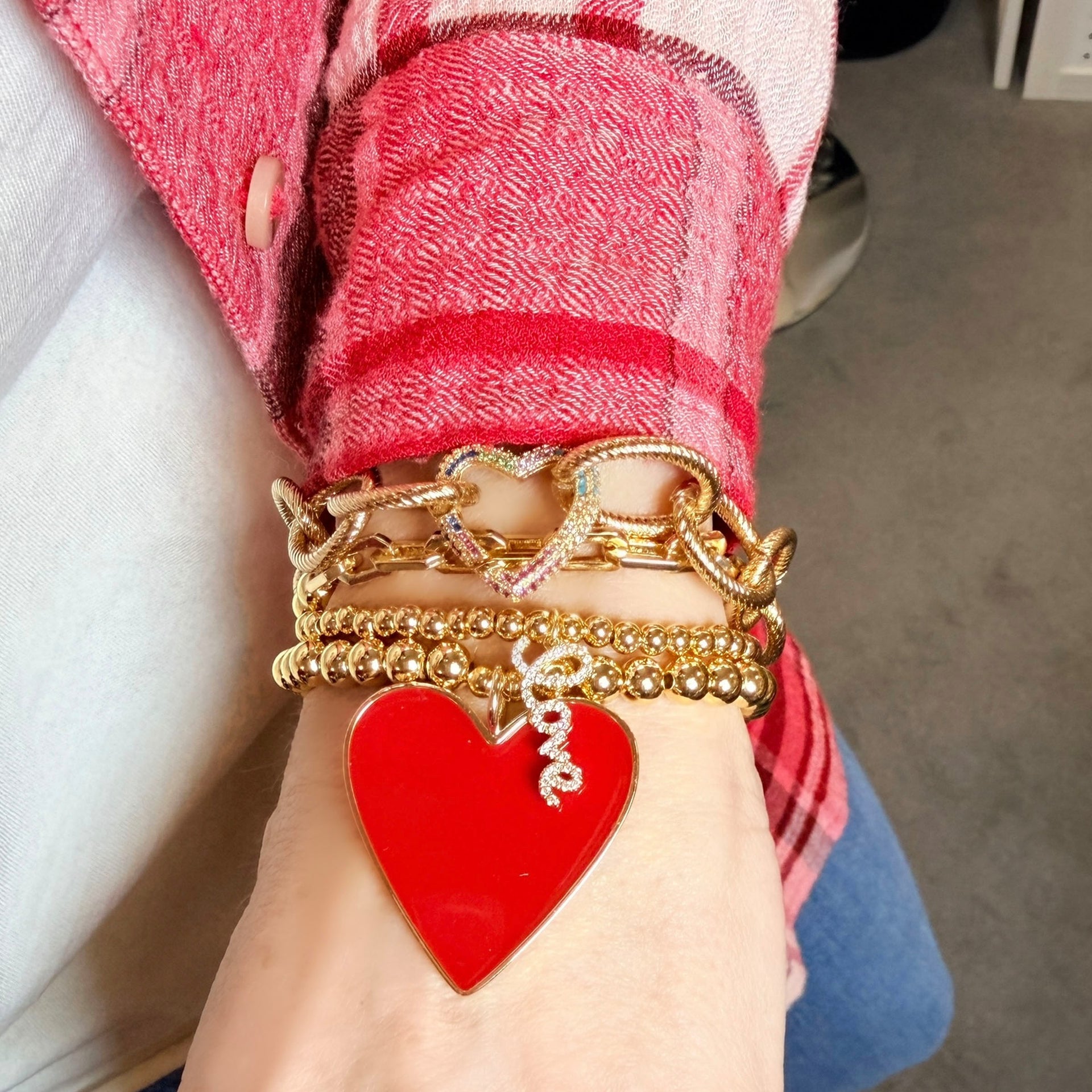 Love Lisa locked in love heart clasp bracelet layered with red and gold heart bracelet stack