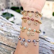 Love Lisa Jewish protection bracelet gold beads stacked on wrist with other bracelets
