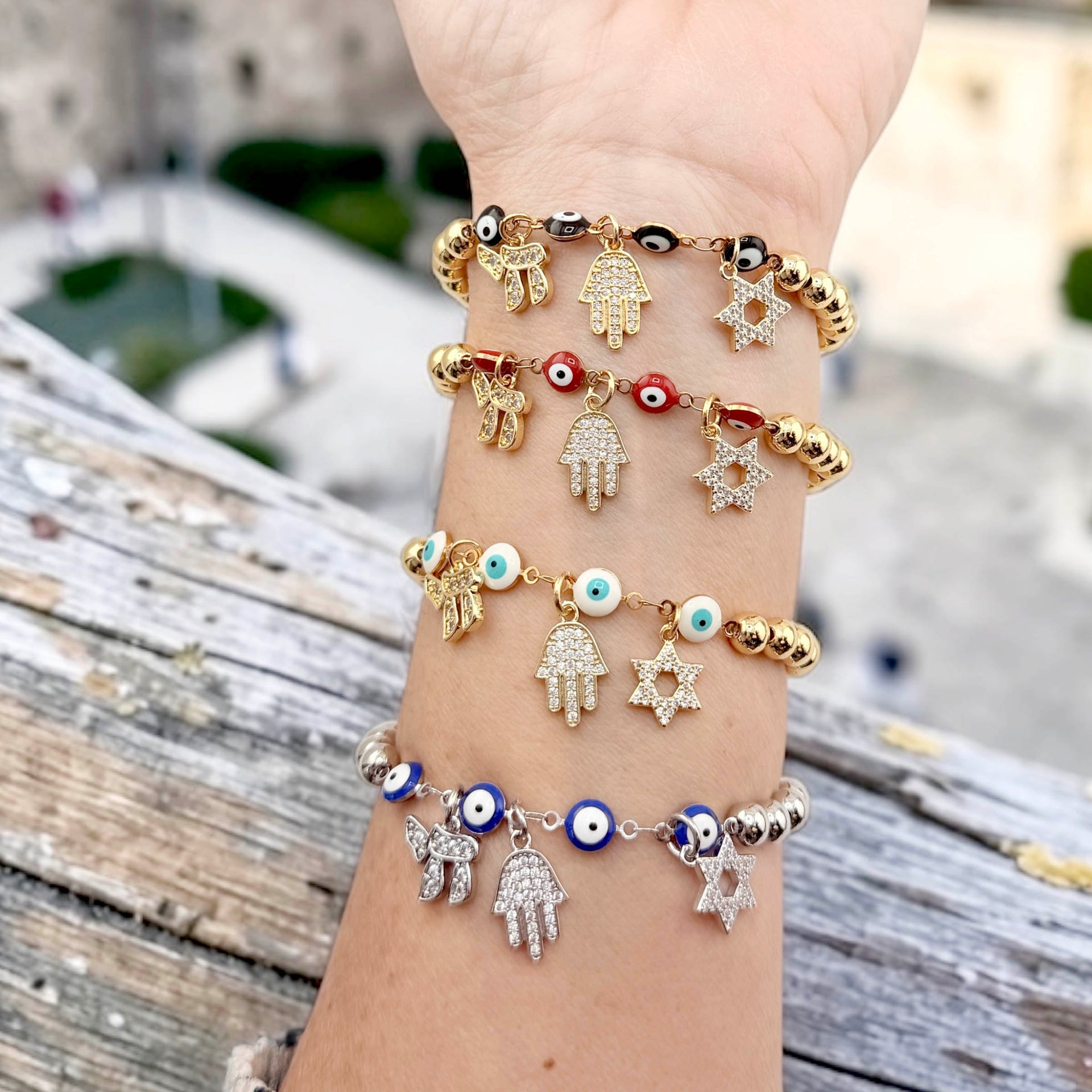 Love Lisa Jewish protection bracelet gold beads stacked on wrist with other bracelets

