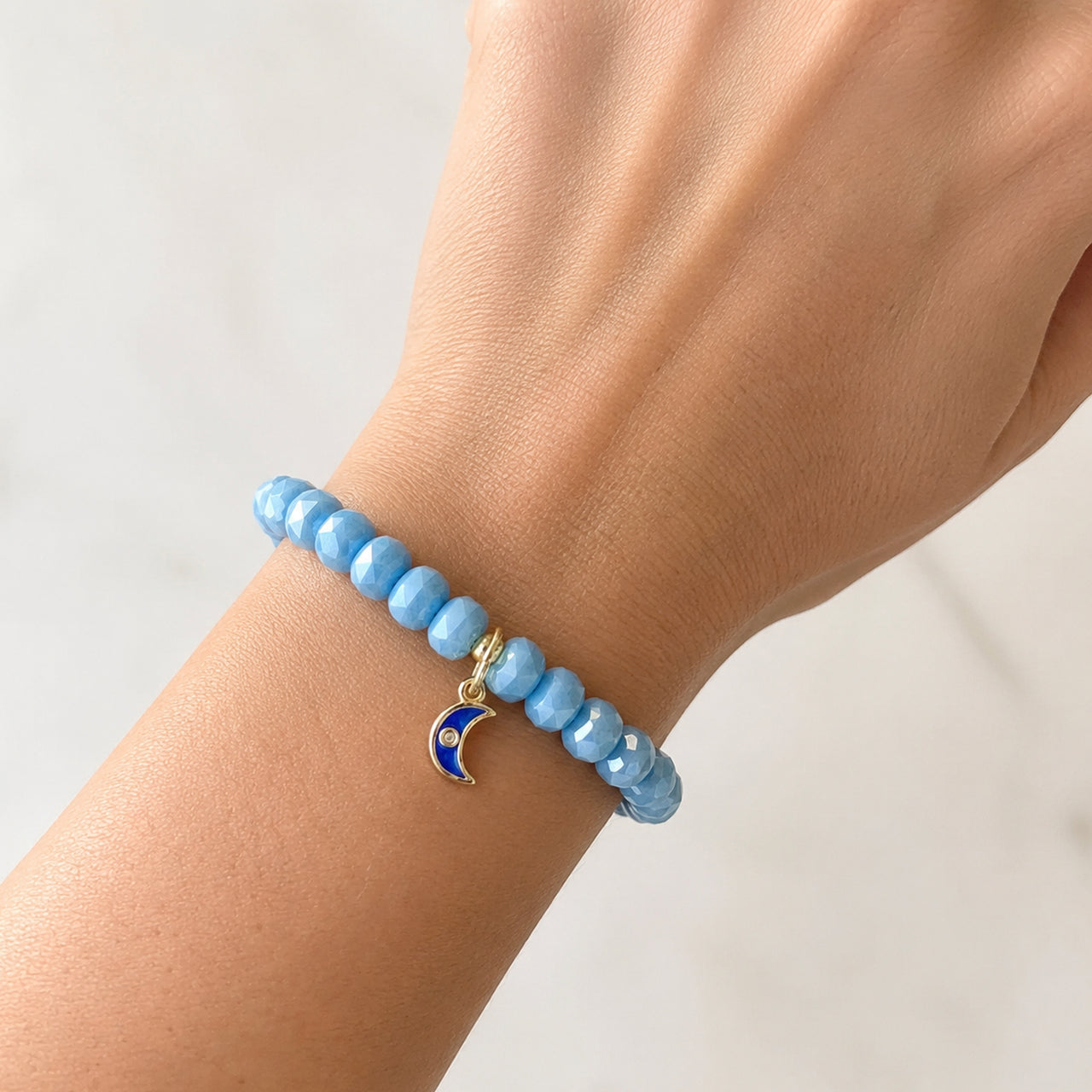 Love Lisa Luna Luxe Moon Charm Crystal Beaded Bracelet worn on wrist in light blue with crescent moon charm