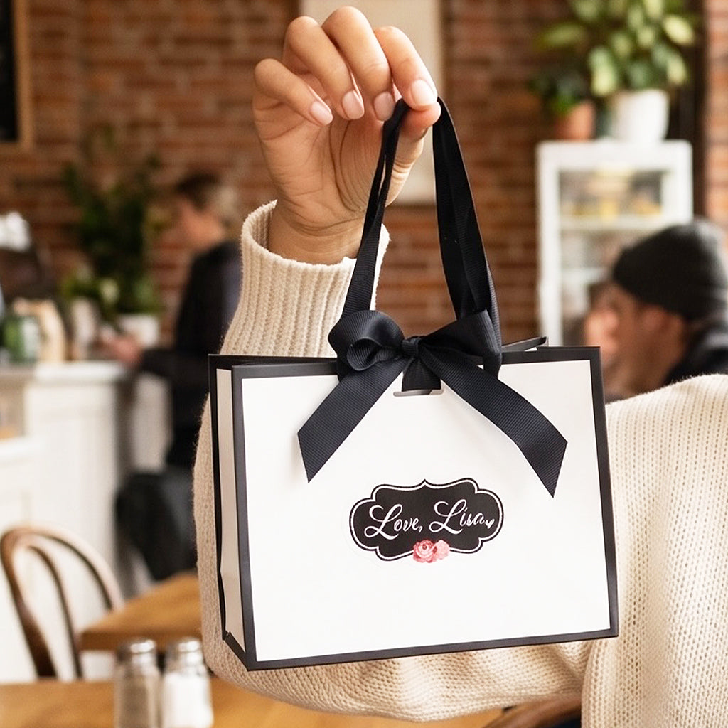 woman holding love lisa gift bag with black ribbon bow