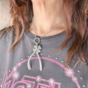 Model wearing silver Luxe Wishbone Sparkle Charm with CZ clover on clasp chain necklace