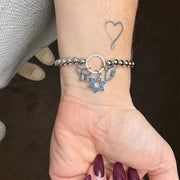 silver beaded charm bracelet with blue pave star of david and pavé chai and evil eye charms on wrist