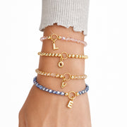 Love Lisa madison initial charm beaded bracelets stacked on wrist showing multiple colors and letter charms
