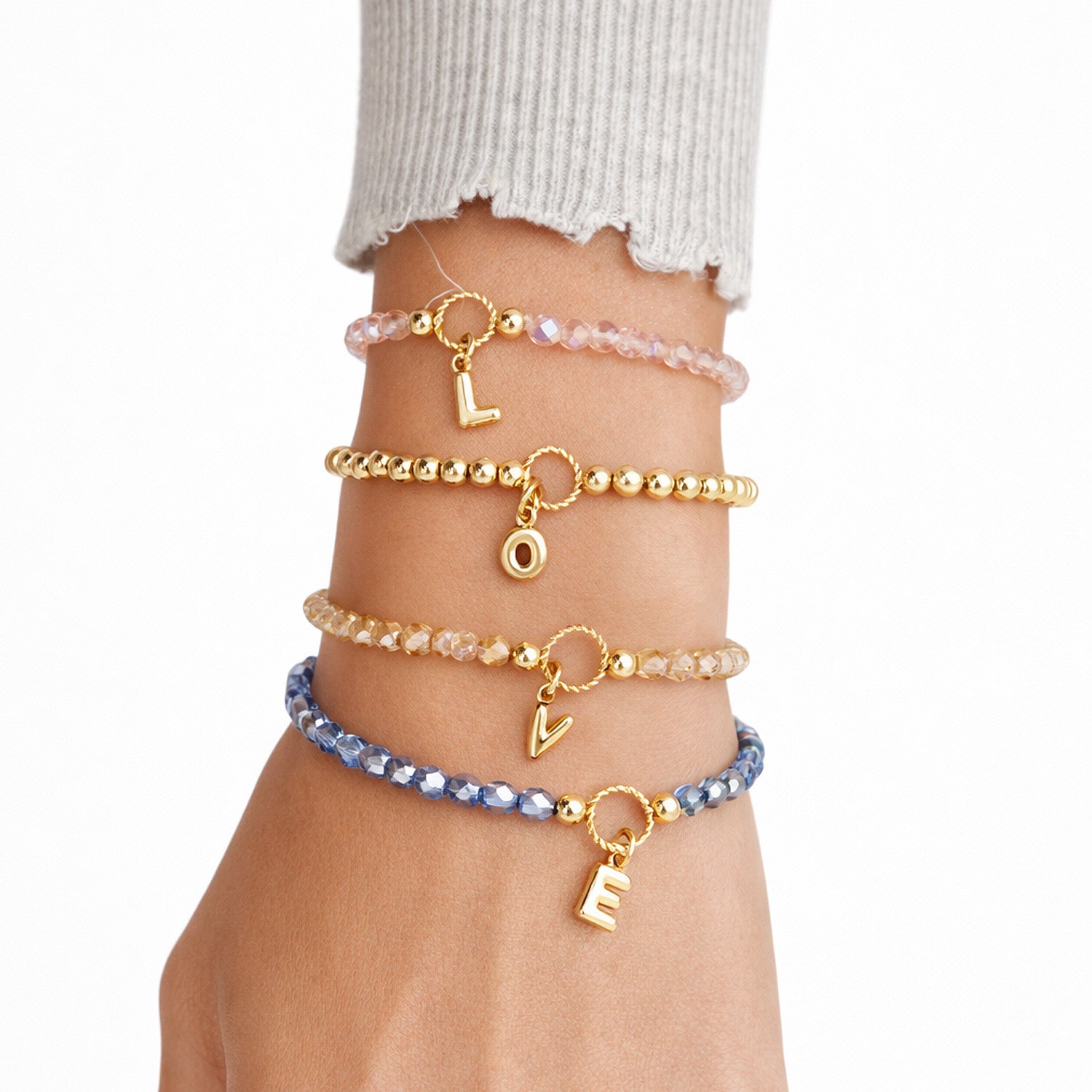 Love Lisa madison initial charm beaded bracelets stacked on wrist showing multiple colors and letter charms

