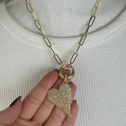 Gold slanted heart charm with shimmering pavé crystals in hand