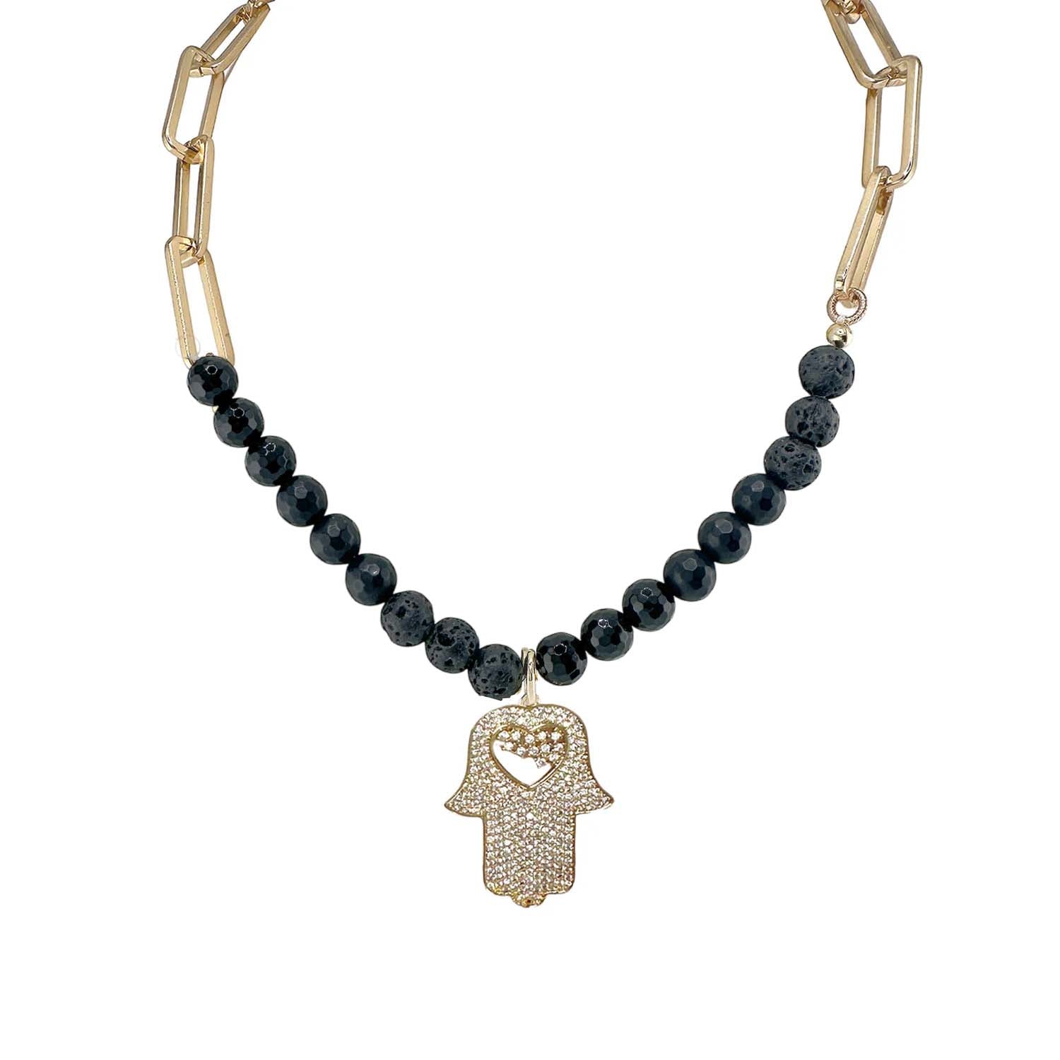 Necklace with black beads and gold Hamsa hand pendant on a white background