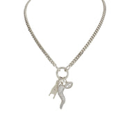 A silver-colored Italian horn (cornicello) necklace with multiple charms, including a hand and an evil eye, displayed against a white background.