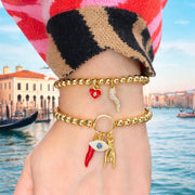 Gold beaded protection charm bracelet with cornicello, evil eye, and hand charms by Love, Lisa