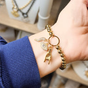 Love Lisa gold italian horn evil eye bracelet worn on wrist showing charm detail and movement
