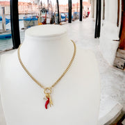 gold mariano italian protection charm necklace displayed on stand with cornicello evil eye and mano charms