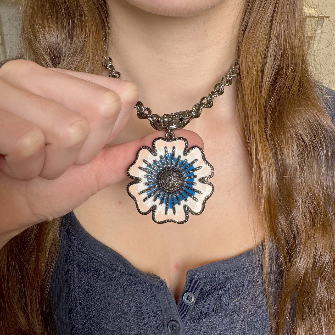 Martina Flower Charm in black gunmetal with sapphire blue enamel and pavé border on a model