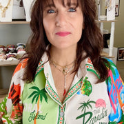 Model wearing gold Martina Necklace with layered paperclip chain and protective charms.