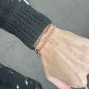 mary diamond cross bracelet rose gold worn on model with layered bracelets love lisa