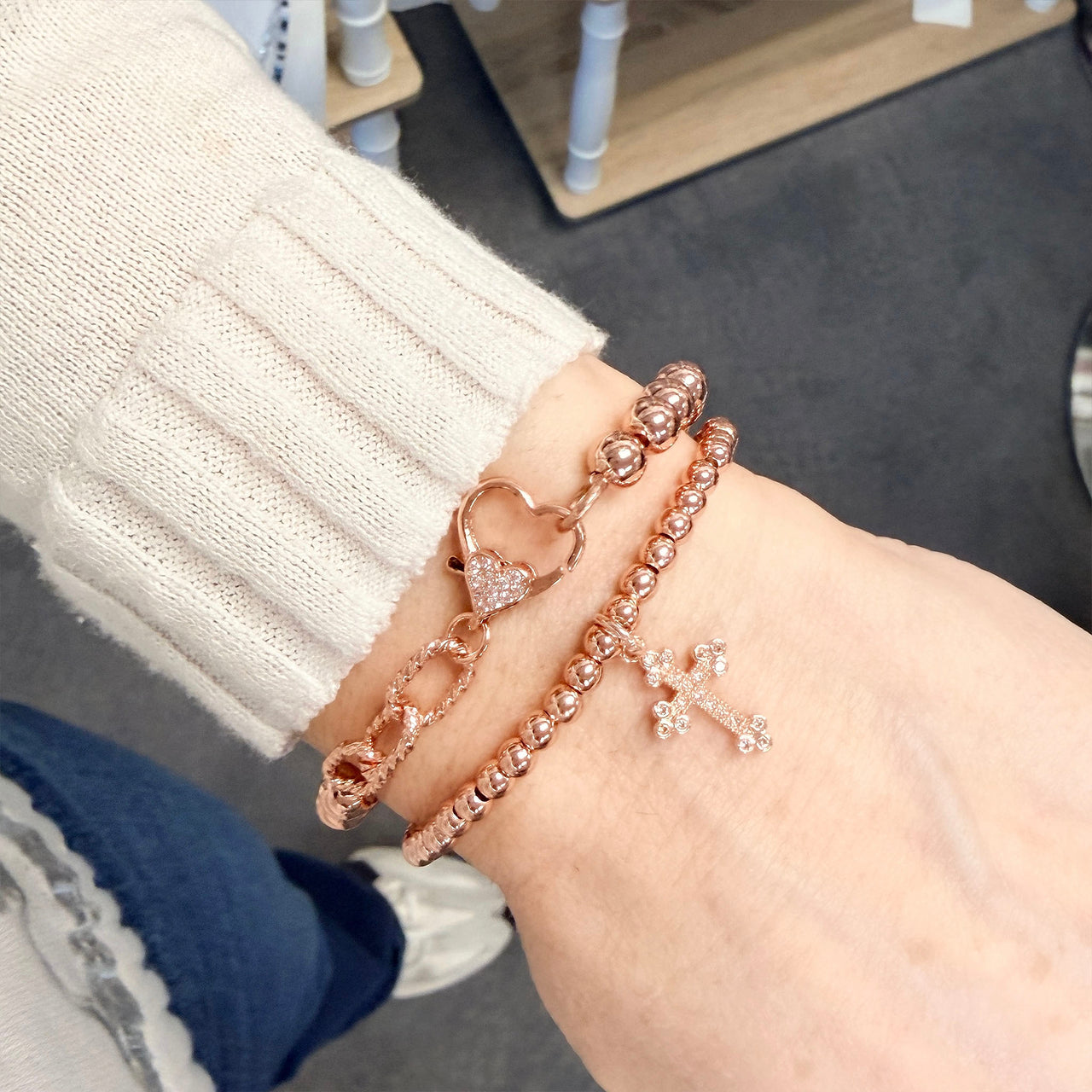 mary diamond cross bracelet rose gold worn on model with layered bracelets 