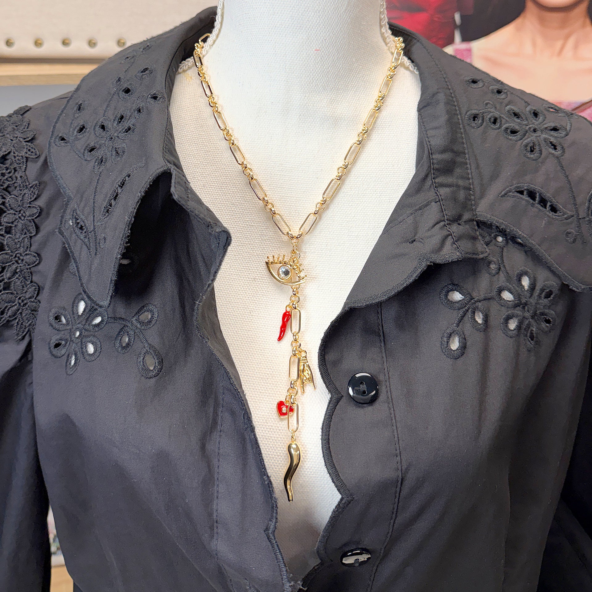 Italian charm Y necklace displayed showing evil eye centerpiece and layered protection charms