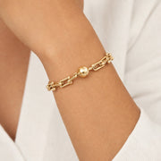 Mila magnetic link bracelet gold worn on wrist with polished gold chain and magnetic clasp on white background