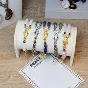 Close view of Miraculous Rosary stretch bracelet highlighting cross charm and bead detailing
