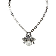 Necklace with a pendant featuring a pearl and intricate design on a white background