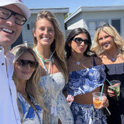 Group of models wearing love lisa jewelry posing outdoors, enjoying drinks and each other's company.