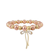 rose gold beaded bow charm bracelet modern feminine accessory for everyday wear