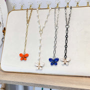 Necklaces with butterfly pendants on a display stand