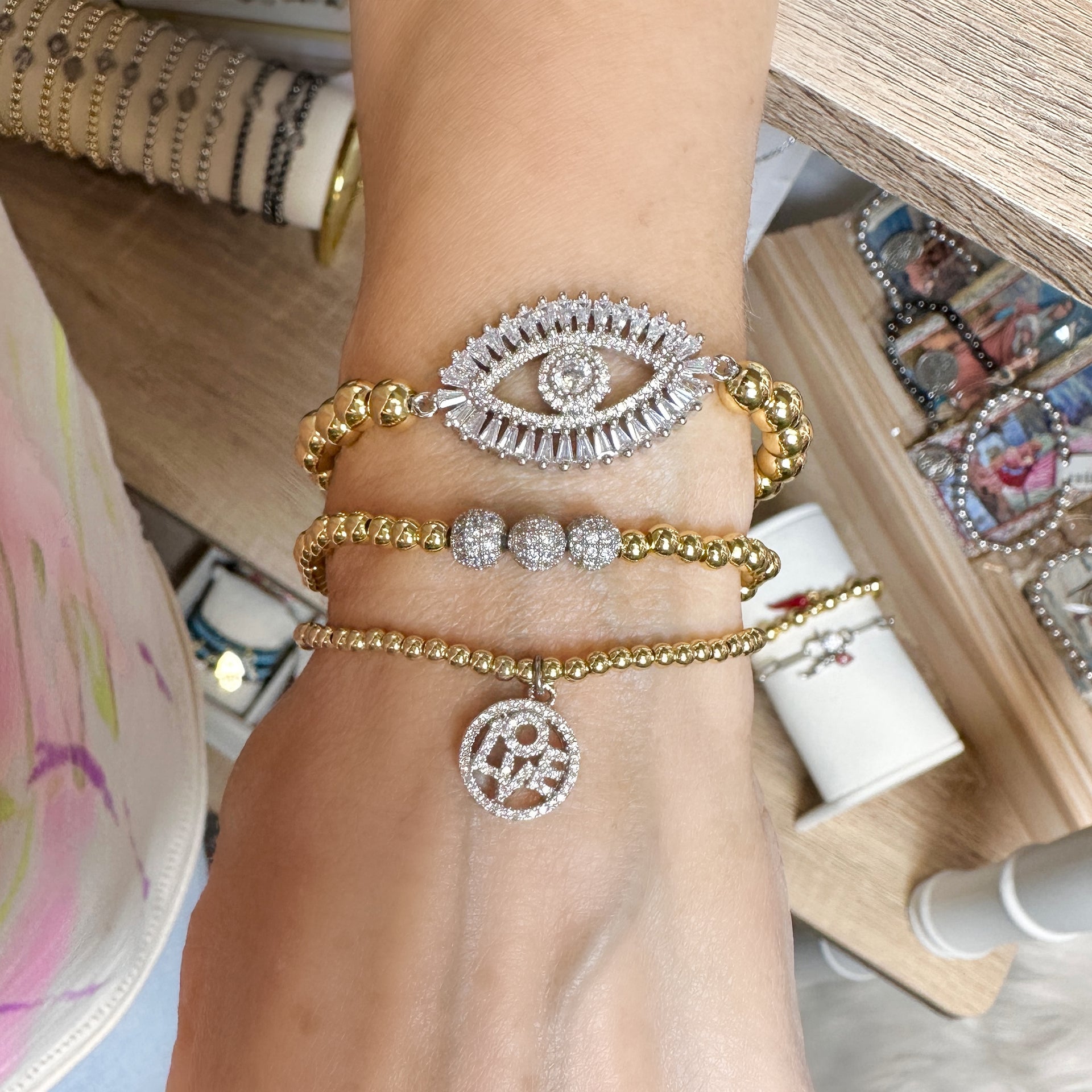 Monica Evil Eye Beaded Bracelets by Love Lisa stacked on wrist in assorted metallic finishes
