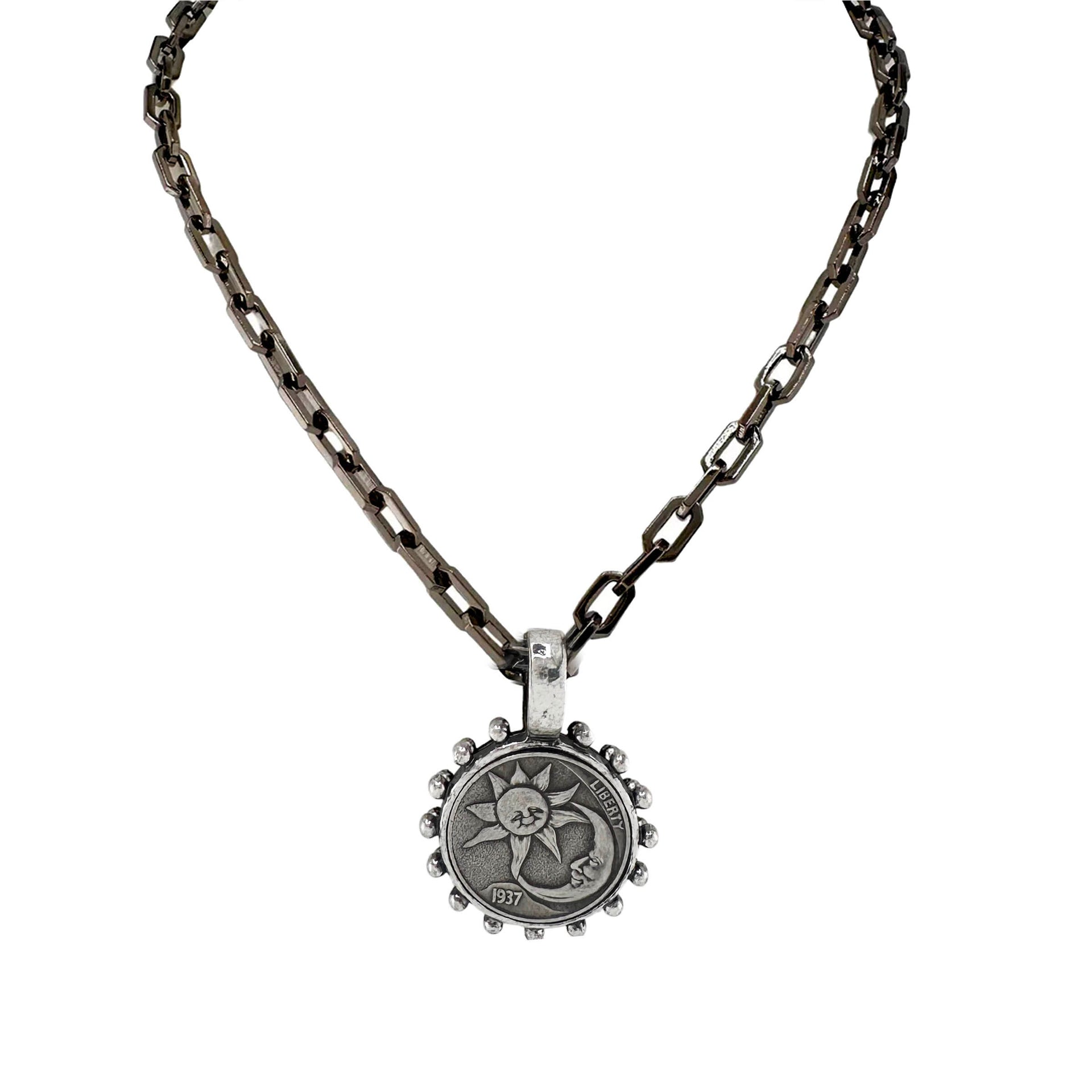 Necklace with a sun coin pendant on an oxidized chain against a white background