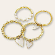 mother of pearl girl bracelet set flatlay gold beads pearl accents heart charms