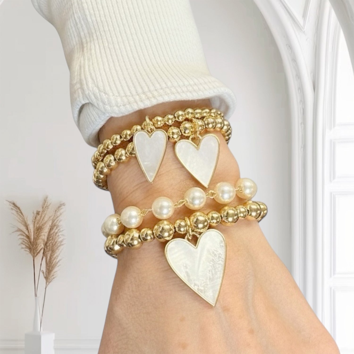 mother of pearl girl bracelet stack worn layered gold and pearl heart charms