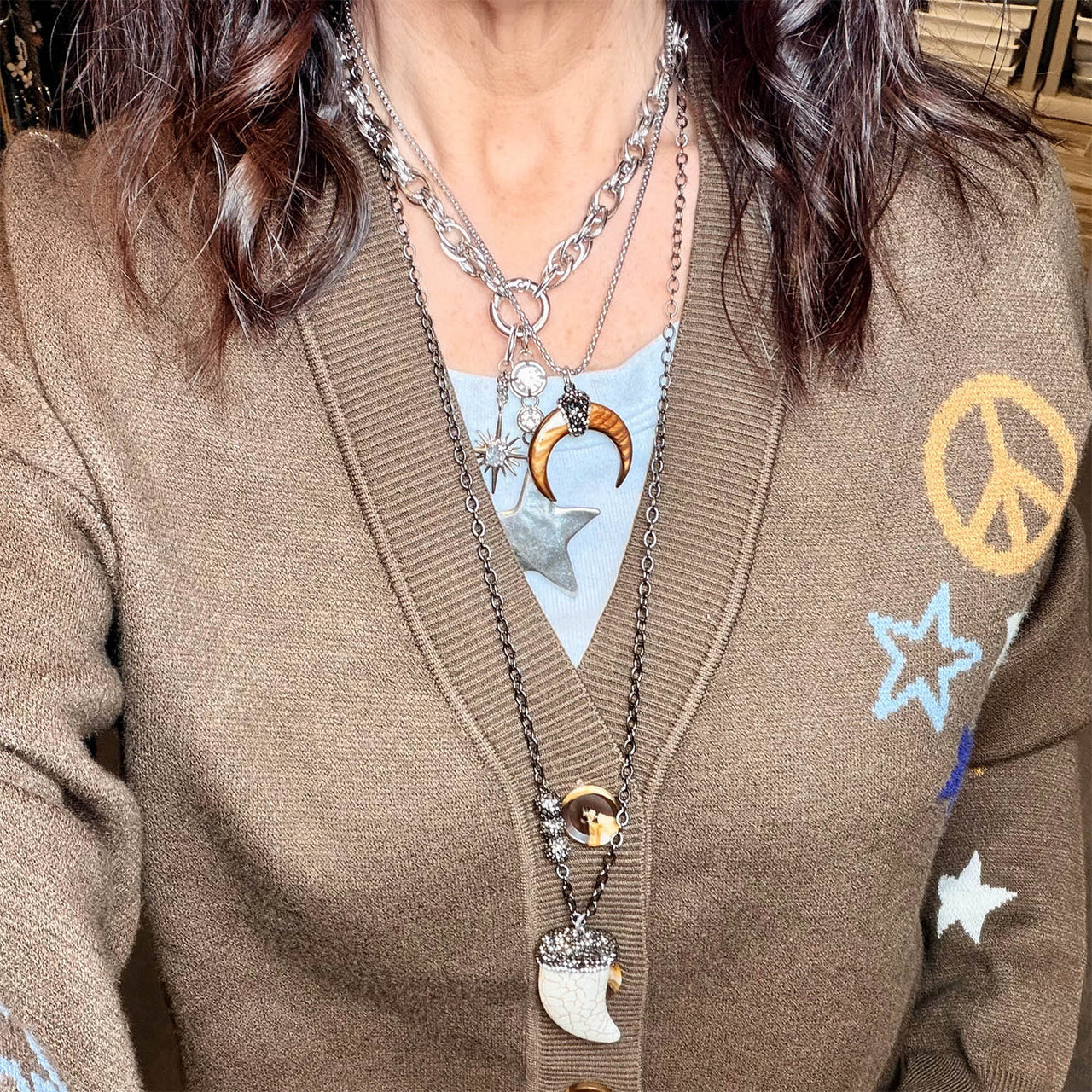 model wearing silver natural shell horn pendant necklace with crescent pendant and pave crystal details by Love Lisa