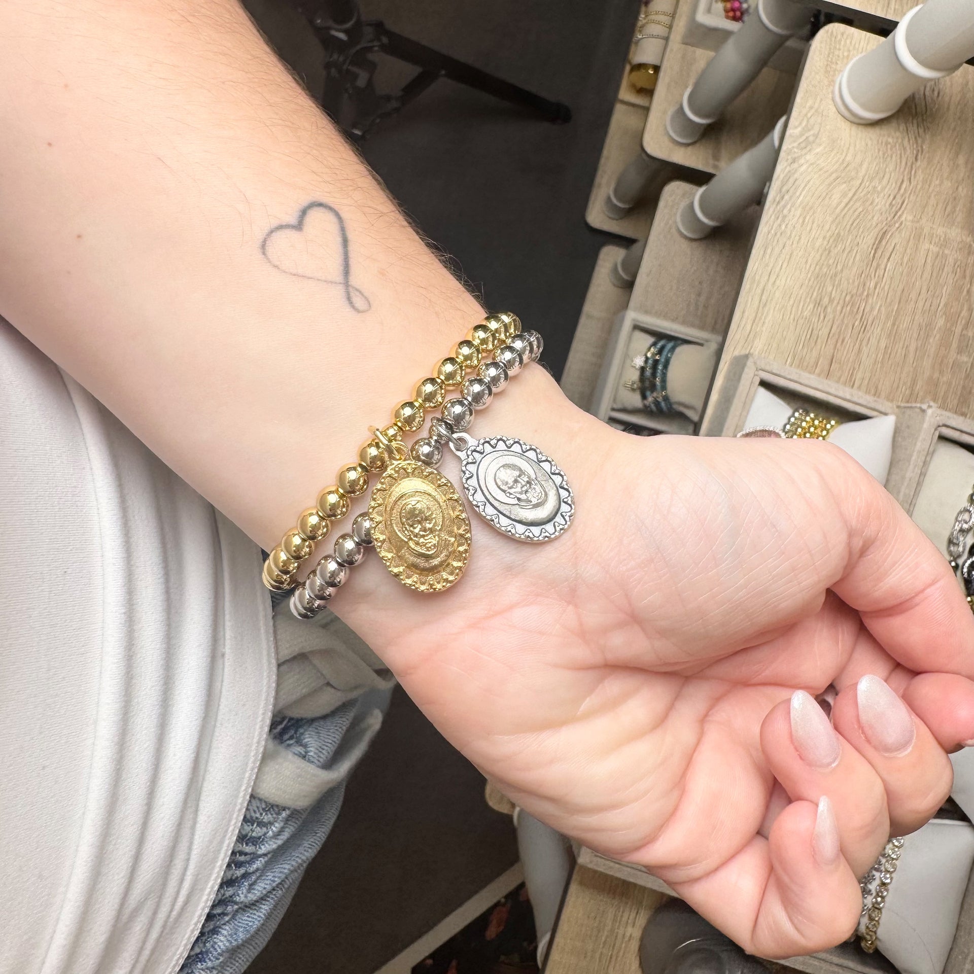 padre pio healing charm bracelet shown on wrist in silver and gold