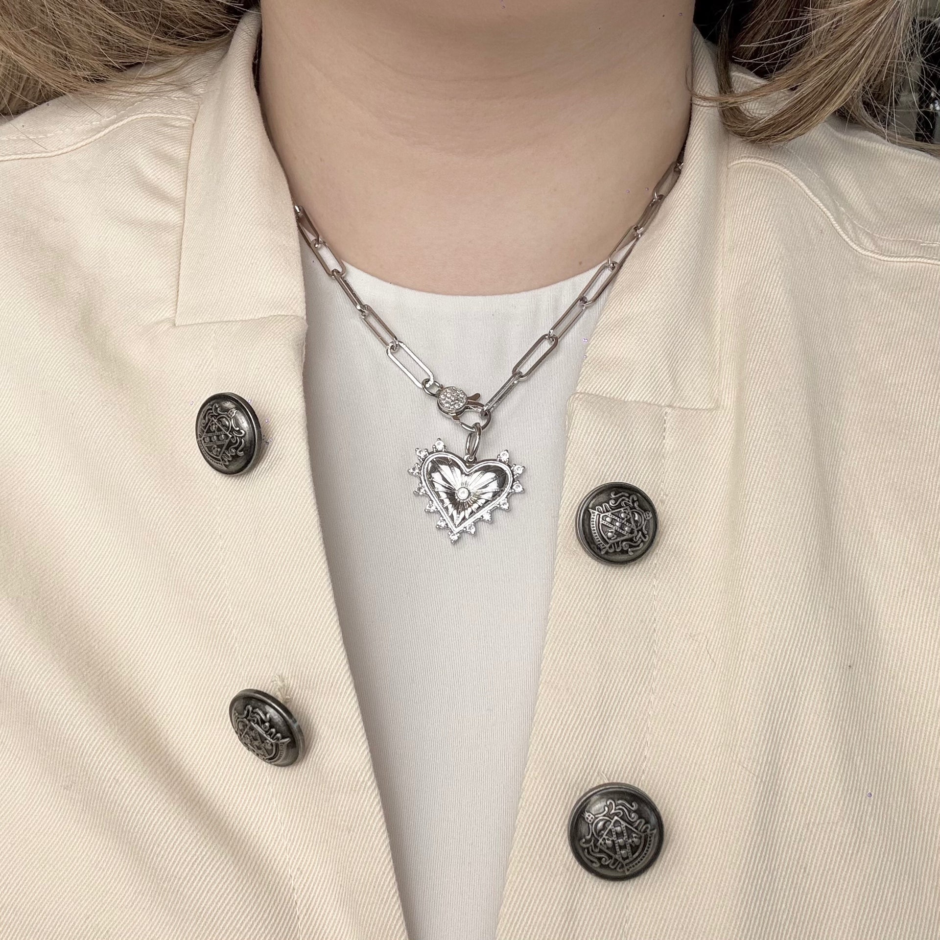 model wearing love lisa silver paperclip clasp necklace layered with heart charm charm bar jewelry