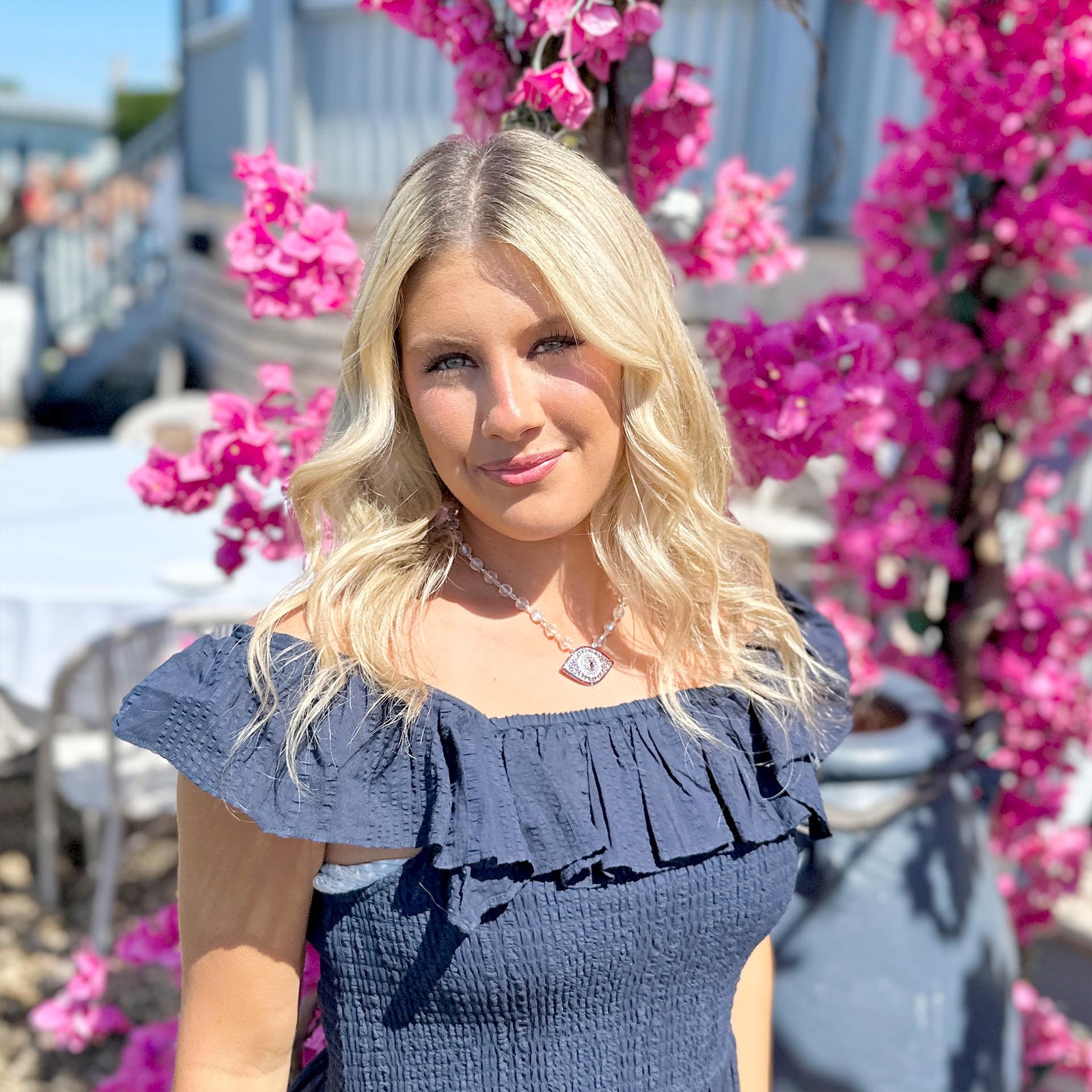 Woman in a blue dress with pink flowers in the background