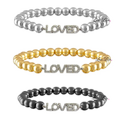 Three beaded bracelets with 'LOVED' charm in silver, gold, and black on a white background.