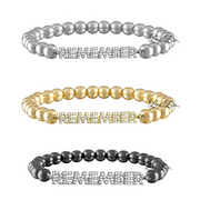 Three beaded bracelets in silver, gold, and black with embedded stones on a white background.