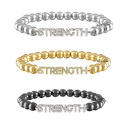 Three 'STRENGTH' beaded bracelets in silver, gold, and black on a white background.