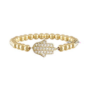 A gold-colored beaded bracelet with a Hamsa charm featuring a geometric pattern of beads and crystals.