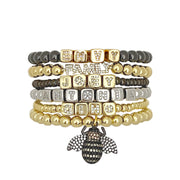 stack of personalized name bracelets in gold silver and gunmetal with block letters by love lisa