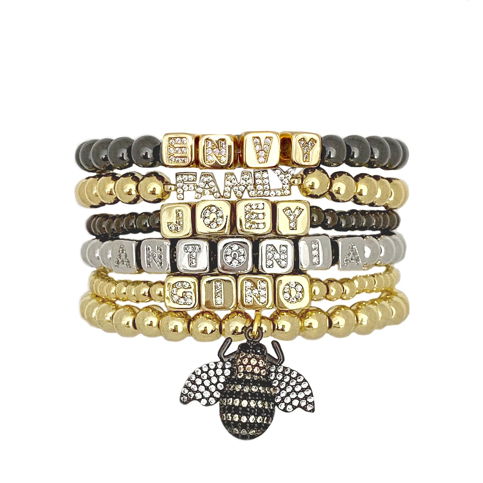 stack of personalized name bracelets in gold silver and gunmetal with block letters by love lisa