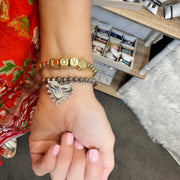  Gold LOVE block letter bracelet stacked with silver beaded heart charm bracelet on wrist